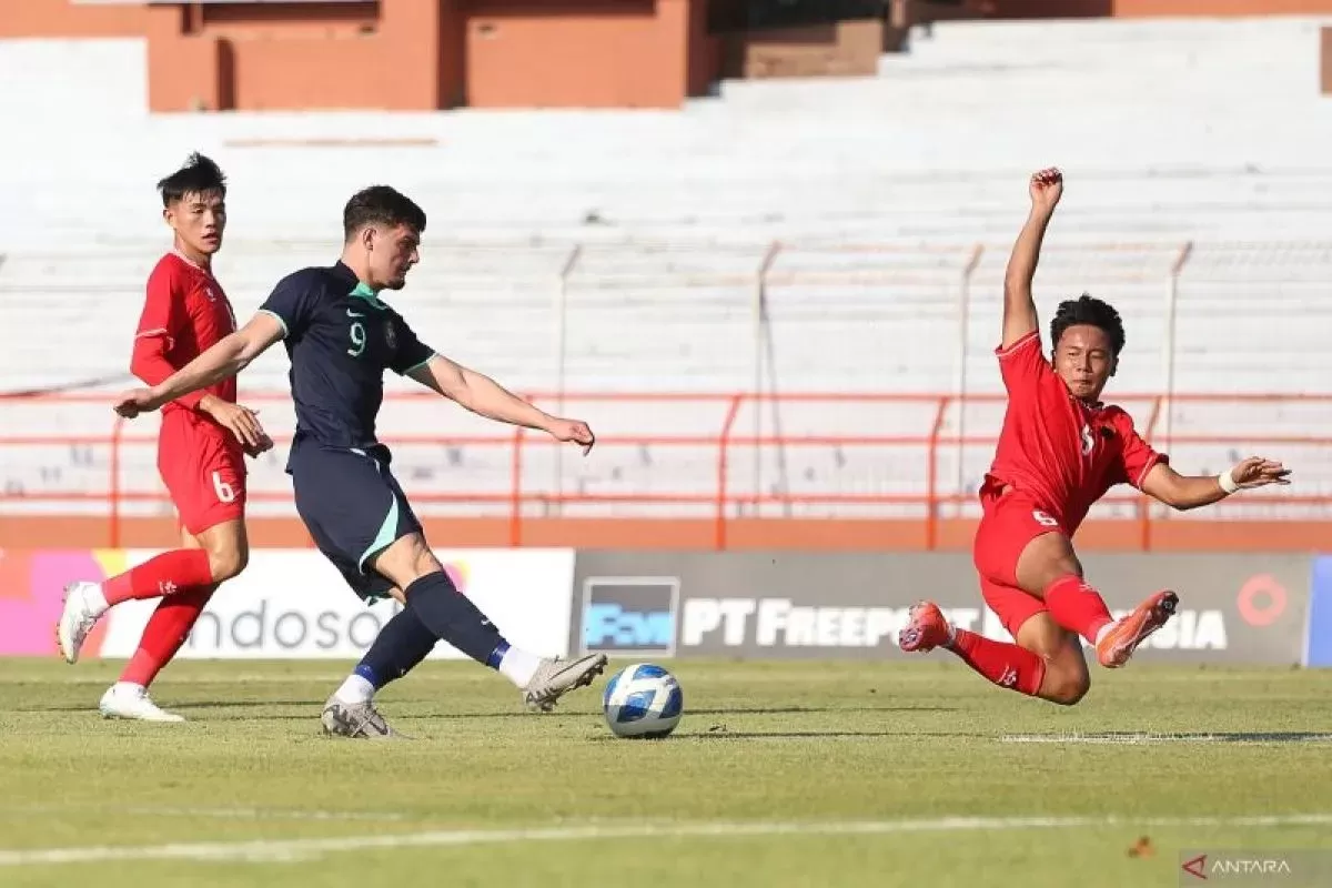 Pesepak bola Timnas Australia Arion Sulemi (tengah) menendang bola dan coba ditahan pesepak bola Timnas Vietnam Nguyen Quoc Khanh (kanan).